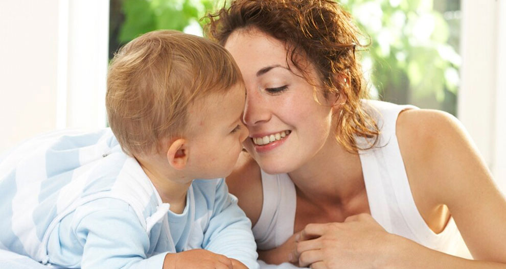 A woman and a baby share a tender moment.